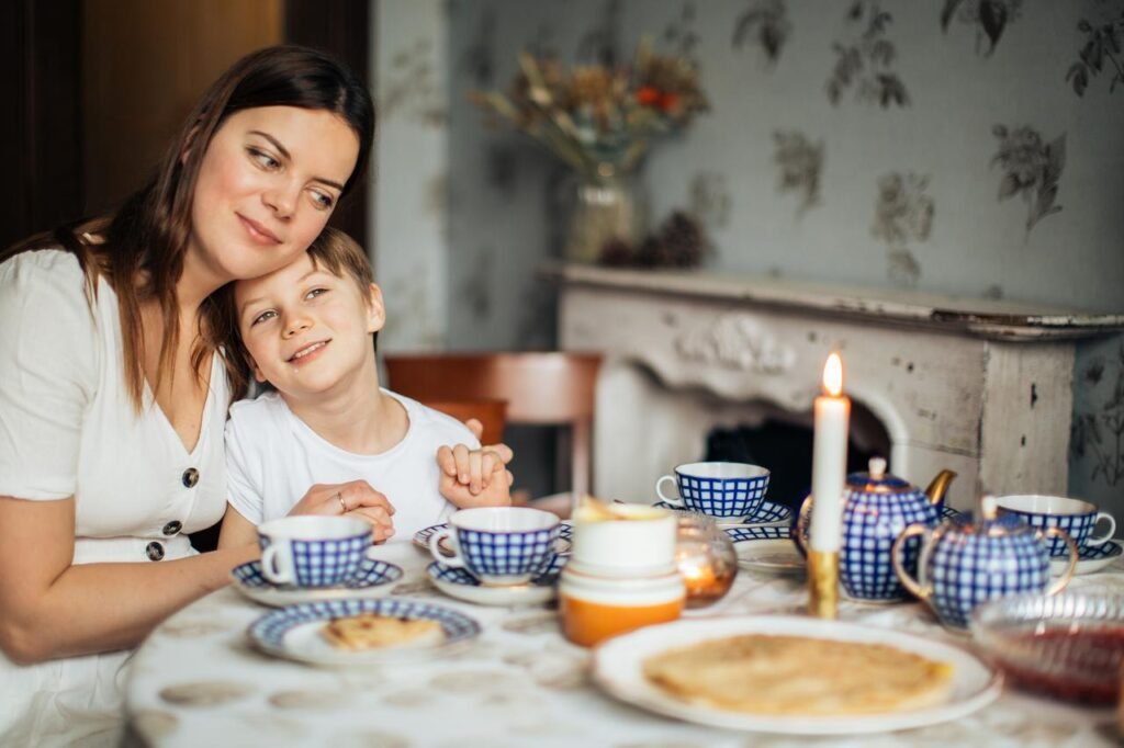 MATKOWANIE FACETOWI, KOBIETA SIEDZI PRZY STOLE,  TULI Z UŚMIECHEM SWOJEGO SYNA