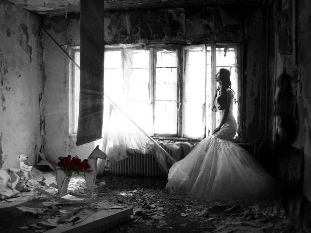Czy cierpienie uszlachetnia, kobieta stojąca w sukni ślubnej w opuszczonym pokoju