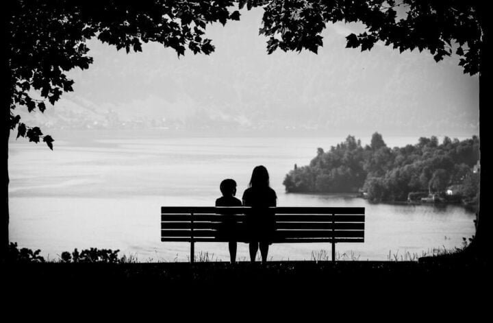 Zamknąć rozdział w życiu, dwie postacie siedzące razem na ławce spoglądają w stronę jeziora